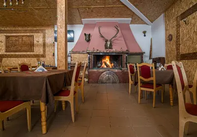 a dining room with a fireplace and a table and chairs at Kamena Pamporovo in Pamporovo