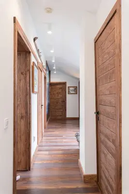 a hallway with wooden doors in a house at Finest Luxury Penthouse Bansko Royal Towers in Bansko