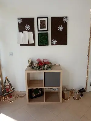 a room with a tv and christmas decorations on a wall at Синьо небе in Bansko