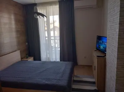 a bedroom with a bed and a television and a window at St John Park Boutique room Gero in Bansko