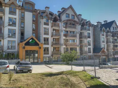 a large building with cars parked in front of it at St John Park Boutique room Gero in Bansko