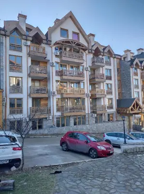a large apartment building with cars parked in a parking lot at St John Park Boutique room Gero in Bansko