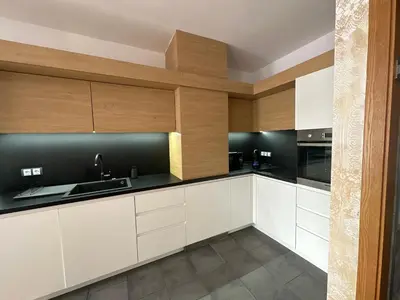 a kitchen with white cabinets and black countertops at Silver city Paradise in Sofia