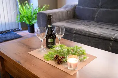 a bottle of wine and two glasses on a coffee table at The White Horse Apartments in Borovets