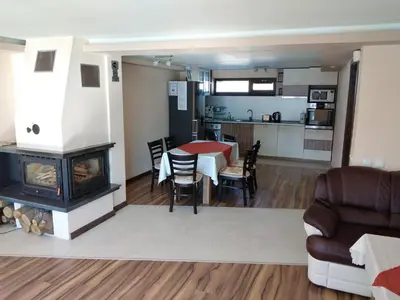 a living room and kitchen with a table and a fireplace at Sveti Nikola Villas near Borovets in Shiroki Dol