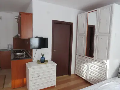 a bedroom with white cabinets and a white dresser at Flora Violet Studio Apartment nr 10 in Borovets