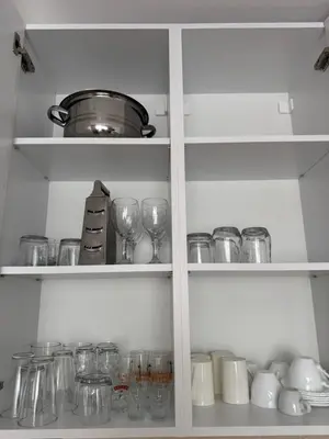 a cabinet filled with glasses and a pot at Relax&Ski apartment in Bansko