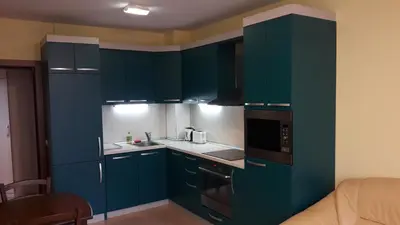 a kitchen with blue cabinets and a stove top oven at Apartament Fantasy Hisarya in Hisarya