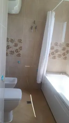 a bathroom with a toilet and a tub and a sink at Apartament Fantasy Hisarya in Hisarya