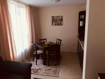 a dining room table and chairs in a room at Marina Apartments - One Bedroom in Bansko