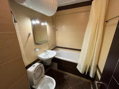a bathroom with a toilet and a sink and a bath tub at Marina Apartments - One Bedroom in Bansko