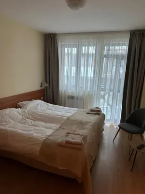 a bedroom with a bed and a chair and a window at Apartment in Castle 1 in Pamporovo