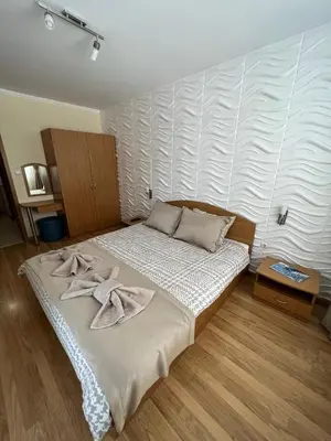 a bedroom with a bed with towels on it at Мезонет Лапландия in Pamporovo