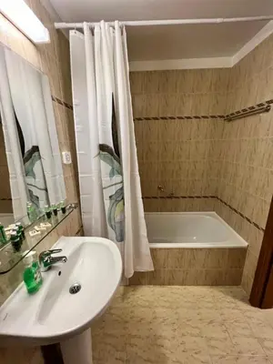 a bathroom with a sink and a bath tub at Мезонет Лапландия in Pamporovo
