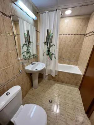 a bathroom with a toilet and a sink and a tub at Мезонет Лапландия in Pamporovo