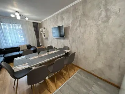 a dining room with a table and chairs and a couch at Мезонет Лапландия in Pamporovo