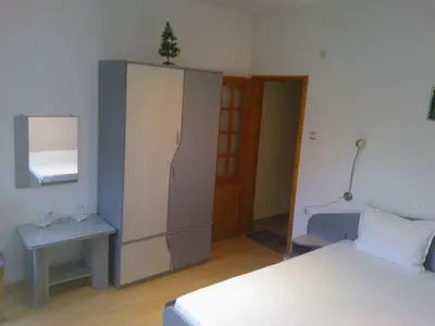 a bedroom with a bed and a cabinet with a tree on top at Hotel Tsarevets in Asenovgrad