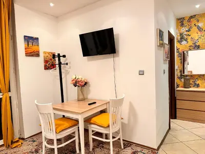 a dining room with a table and chairs and a tv at Private Studio Center Opera and Nevski Cathedral in Sofia