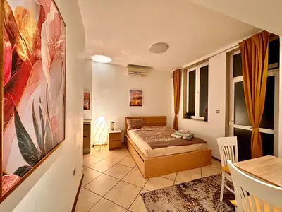 a bedroom with a bed and a table in a room at Private Studio Center Opera and Nevski Cathedral in Sofia