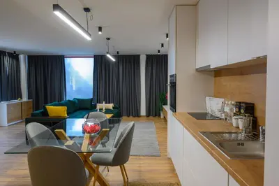 a kitchen and a living room with a glass table at Гардън Апарт in Blagoevgrad