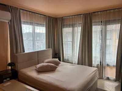 a bedroom with a bed with pillows and windows at Hotel Darling in Bankya