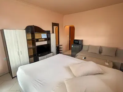 a bedroom with a white bed and a couch at Hotel Darling in Bankya