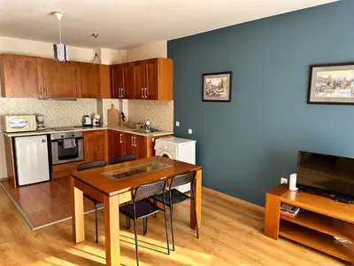 a kitchen with a wooden table and a dining room at Pirin place private apartment in Bansko
