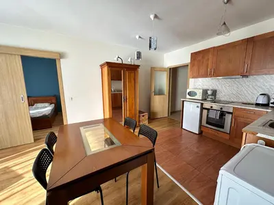 a kitchen with a table and chairs in a room at Pirin place private apartment in Bansko