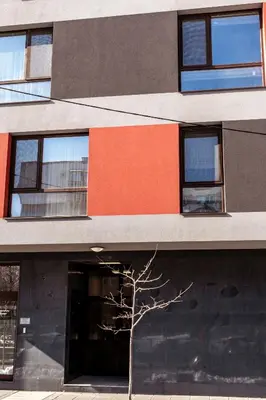 a building with windows and a tree in front of it at Bright 1BDR Apartment with a Balcony in Sofia