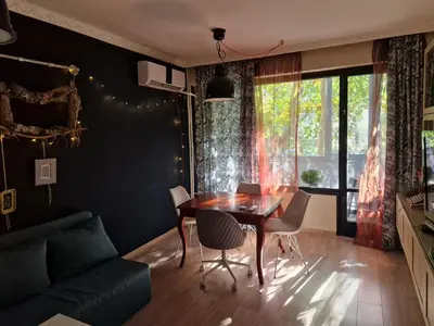 a living room with a table and chairs and a couch at Homey art apartment next to Drujba lake Metro stations and bul.Tsarigradsko Shose in Sofia