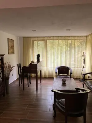 a living room with a table and a piano at Вила Ренесанс Костенец in Kostenets Village
