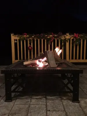 a person is standing next to a fireplace at night at Вила Ренесанс Костенец in Kostenets Village