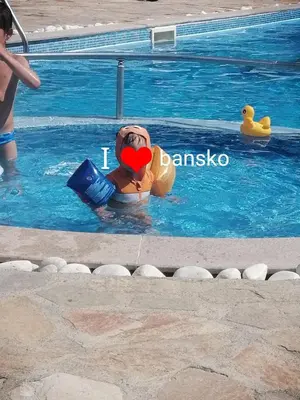 a person in the water in a swimming pool at Bansko Royal Towers T&K in Bansko