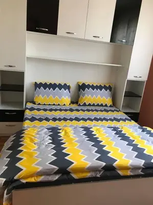 a bedroom with a bed with yellow and blue pillows at Mia's Apartment, Stylish one-bedroom apartment in Sofia