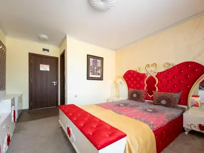 a bedroom with a large bed with a red headboard at Айляк Клуб Велинград - Бутиков Хотел&СПА с Elegant Ultra All Inclusive in Velingrad