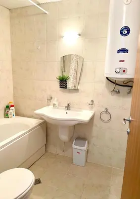 a bathroom with a sink and a tub and a toilet at Pirin Dream View Apartments in Razlog