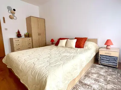 a bedroom with a large bed and a dresser at Pirin Dream View Apartments in Razlog