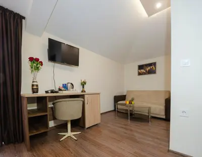 a living room with a desk and a couch at Hotel Central in Karlovo