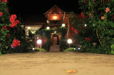 a house with flowers and a gate at night at Orehite Guest House in Samokov