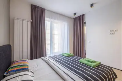 a bedroom with a bed with green towels on it at City Apartments - Mall of Sofia & Metro Station in Sofia