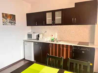 a kitchen with brown cabinets and a sink and a microwave at St. Anastasia Apartments in Bansko