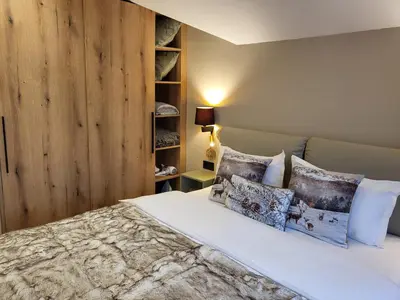 a bedroom with a bed with a wooden wall at PinePino Borovets, aparthotel Borovets Gardens A60 in Borovets