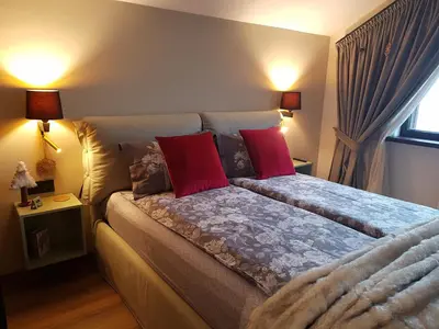 a bedroom with a bed with two red pillows at PinePino Borovets, aparthotel Borovets Gardens A60 in Borovets