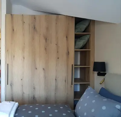 a wooden door in a bedroom with a bed at PinePino Borovets, aparthotel Borovets Gardens A60 in Borovets