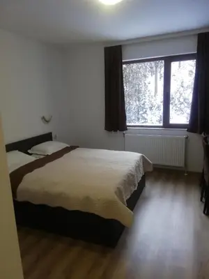 a bedroom with a bed and a large window at Вила ОБЗОР in Progled