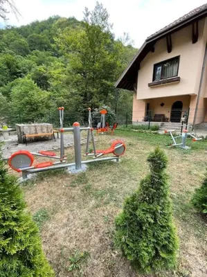 a yard with playground equipment in front of a house at Балкан вили in Ribarica