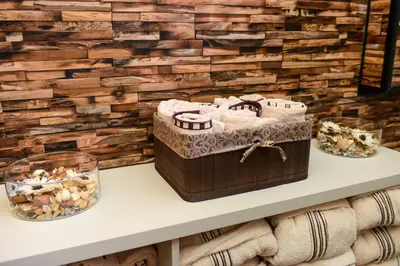 a room with a wooden wall and a table with a box at Балкан вили in Ribarica