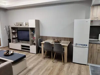 a living room with a table and chairs and a kitchen at Apartment Anelia 1 in Plovdiv