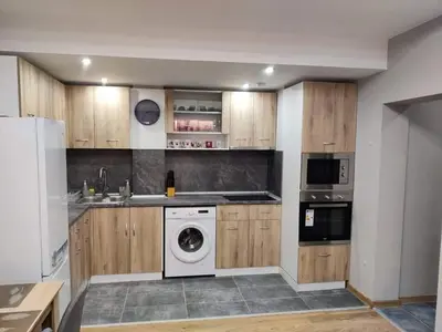 a kitchen with wooden cabinets and a washing machine at Apartment Anelia 1 in Plovdiv