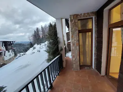 a balcony with a view of a snow covered mountain at Апартамент Amare, Гранд Манастира in Pamporovo
